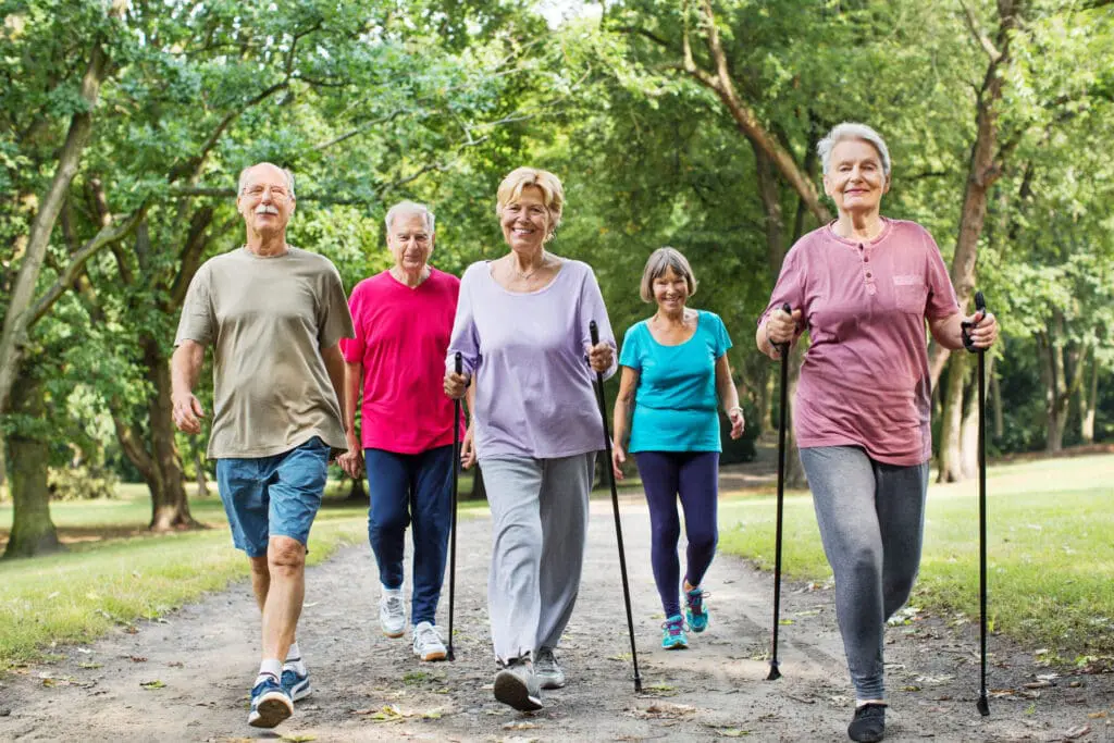 Group of seniors with Parkinson's disease walking in a park near Clarendale West End.